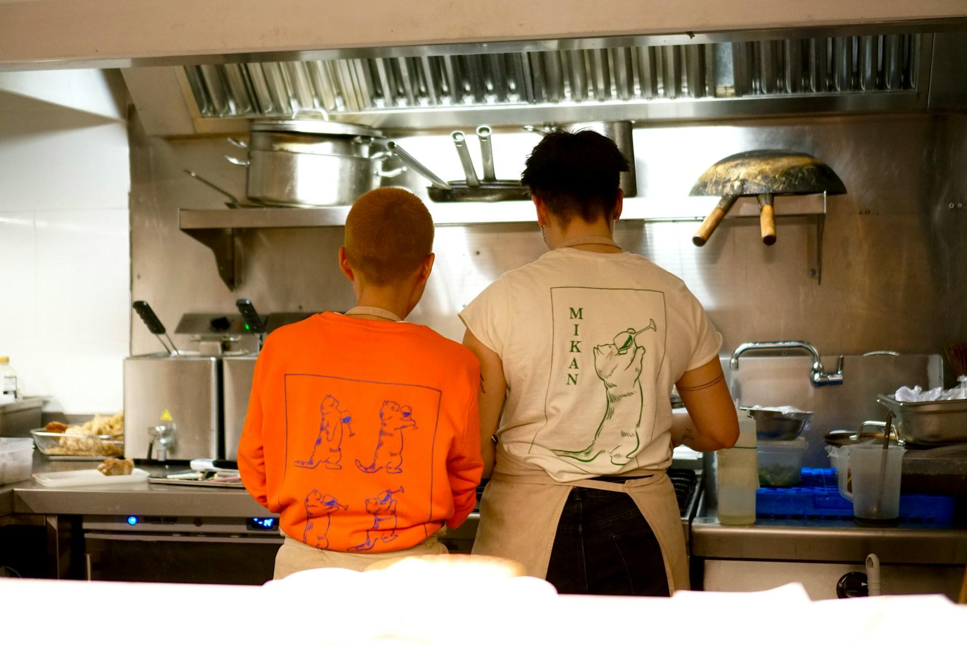 Two people standing in a kitchen next to each other.